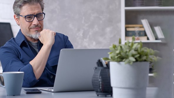 Professional watching training modules on a laptop.